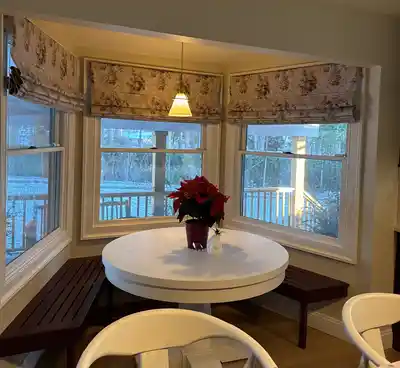 Kitchen bay window with short curtains and a window seat